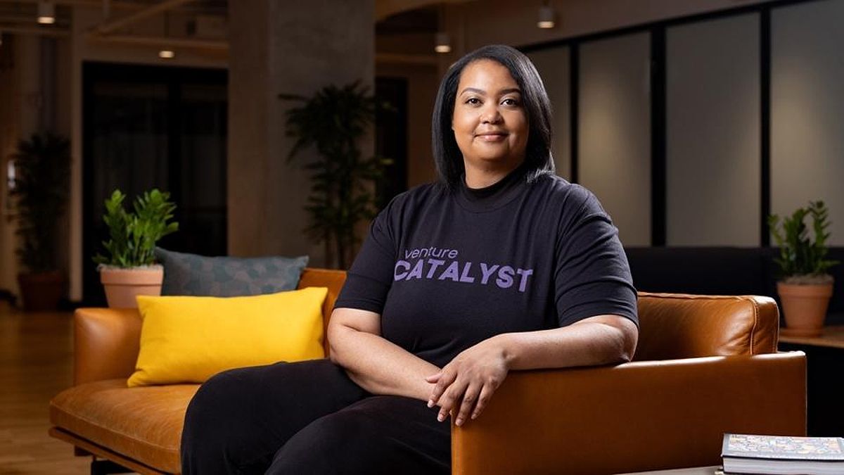 Arlan Hamilton sitting on a couch in a shirt that reads "Venture Catalyst"